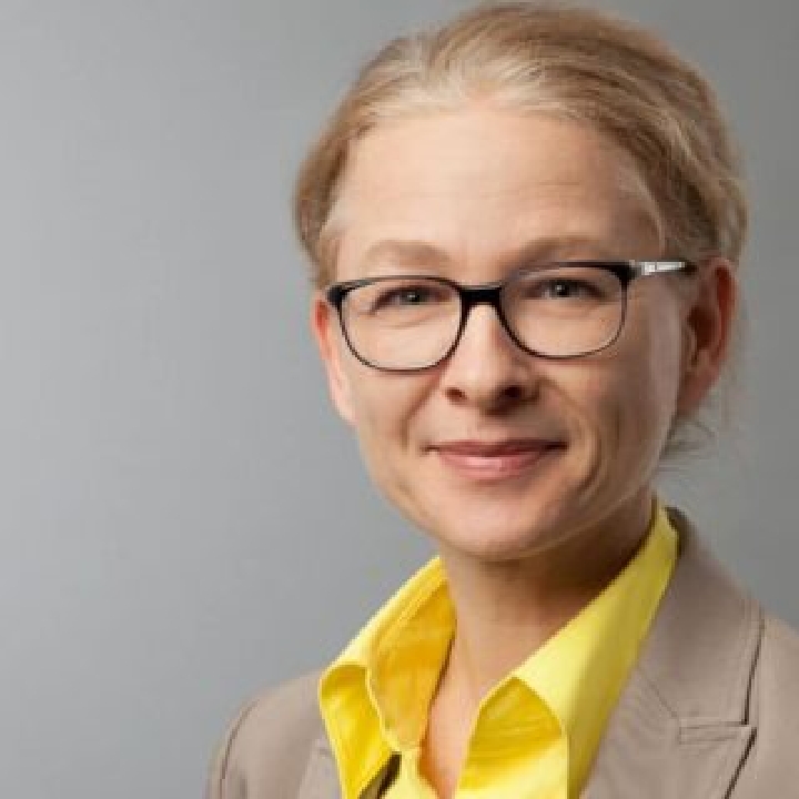 Mirjam Behrends, eine blonde Frau mit Brille und gelbe Bluse.