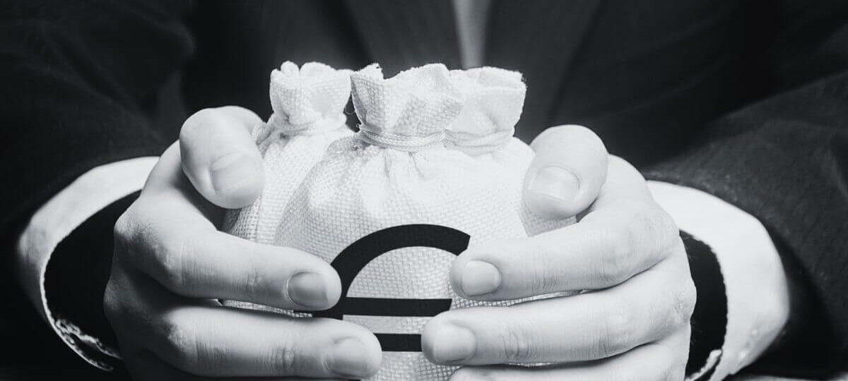 Die Hände eines Mannes halten einen Leinensack mit einem Euro-Zeichen darauf