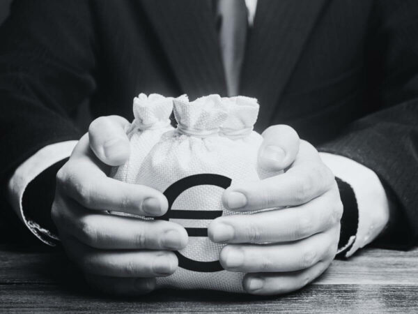 Die Hände eines Mannes halten einen Leinensack mit einem Euro-Zeichen darauf